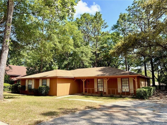 ranch-style home with covered porch, driveway, and a front lawn