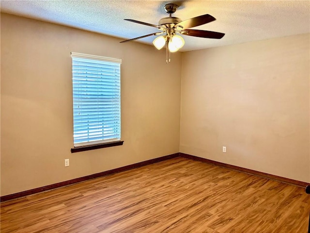 unfurnished room featuring baseboards, a textured ceiling, ceiling fan, and light wood-style flooring