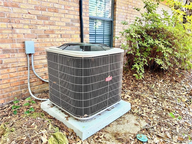 exterior details featuring brick siding and cooling unit