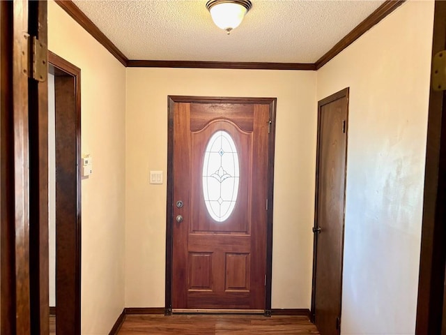 entrance foyer with crown molding, a textured ceiling, baseboards, and wood finished floors
