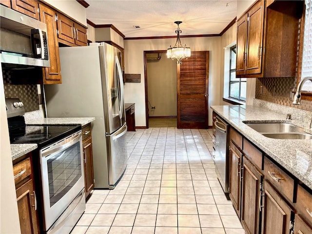 kitchen featuring backsplash, crown molding, appliances with stainless steel finishes, and a sink