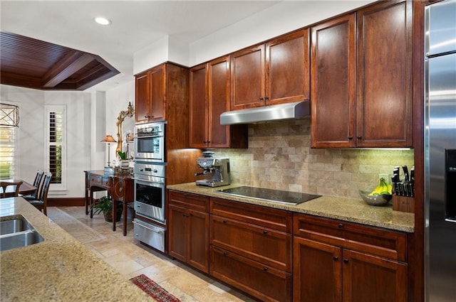 kitchen with backsplash, light stone counters, and appliances with stainless steel finishes