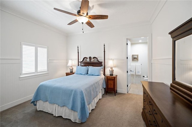 carpeted bedroom with ensuite bath, ceiling fan, and crown molding