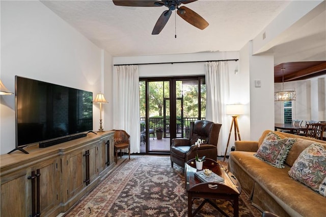 living room with ceiling fan with notable chandelier