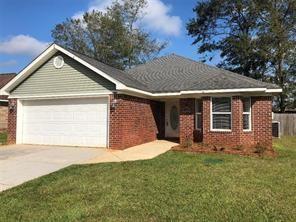 view of front of property with a garage, driveway, brick siding, and a front yard