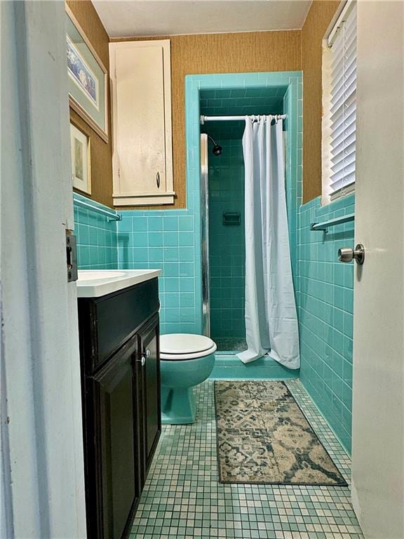 bathroom featuring vanity, toilet, walk in shower, and tile walls