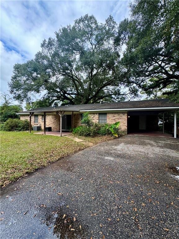 ranch-style home with a front lawn and a carport