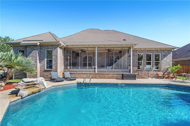 view of swimming pool with a sunroom, ceiling fan, and a patio