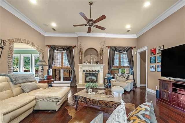 living room with dark wood-type flooring, crown molding, and ceiling fan