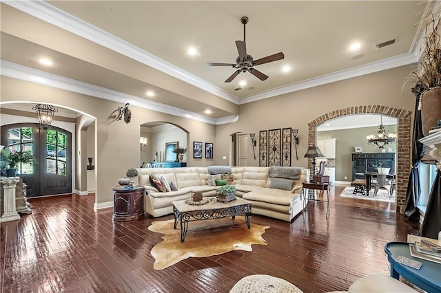 living room featuring french doors, ceiling fan with notable chandelier, dark hardwood / wood-style floors, and ornamental molding