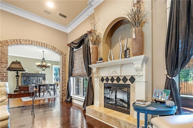 sitting room featuring wood-type flooring, crown molding, and a tiled fireplace