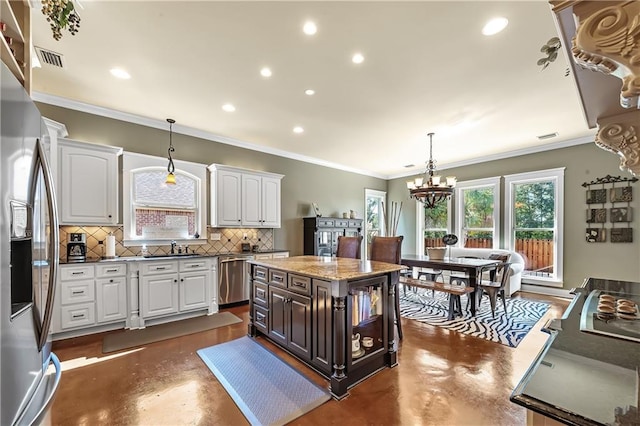 kitchen featuring hanging light fixtures, white cabinetry, a center island, and tasteful backsplash