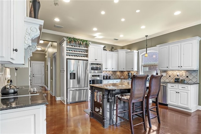 kitchen featuring stainless steel appliances, pendant lighting, a center island, and white cabinetry