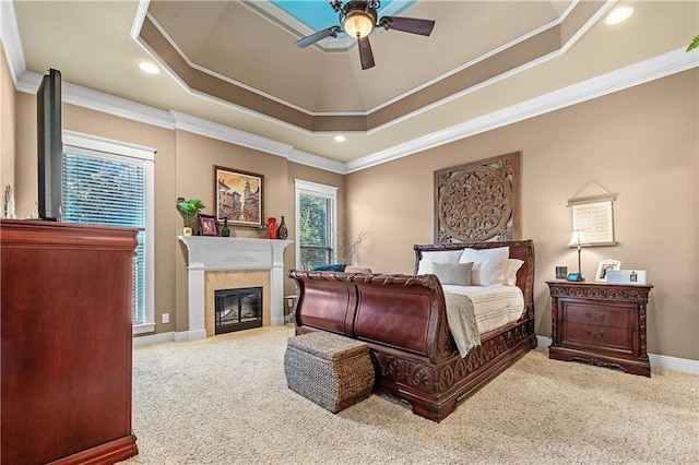 bedroom featuring ornamental molding, a tray ceiling, carpet, and ceiling fan