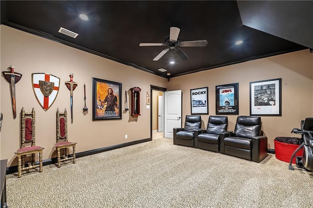 carpeted cinema with ornamental molding and ceiling fan