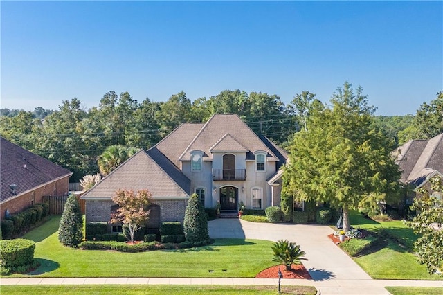 french country inspired facade with a front lawn