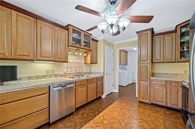 kitchen with light countertops, glass insert cabinets, a sink, washer and dryer, and dishwasher