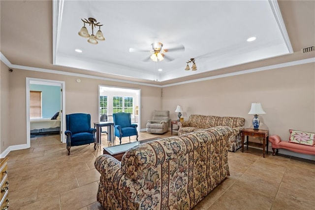 living room featuring ornamental molding, a tray ceiling, and ceiling fan