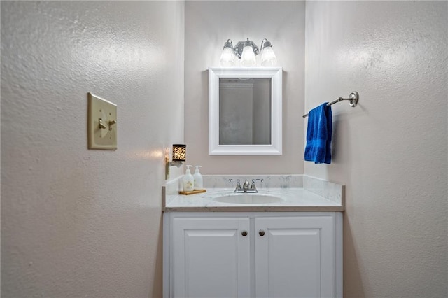 bathroom featuring a textured wall and vanity