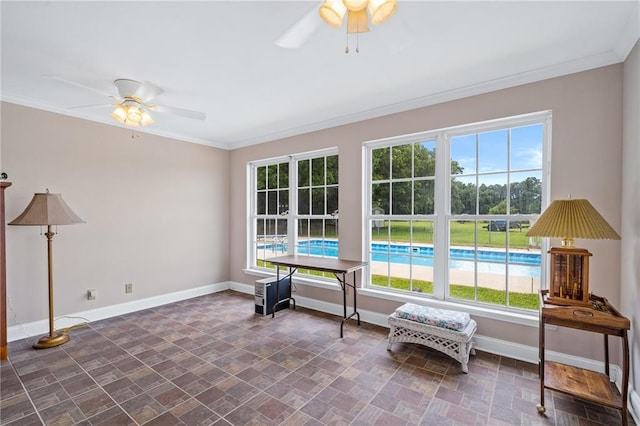 sitting room with baseboards, a ceiling fan, and crown molding