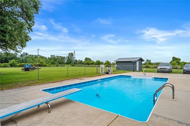 view of swimming pool with a fenced in pool, a lawn, an outbuilding, a storage unit, and fence