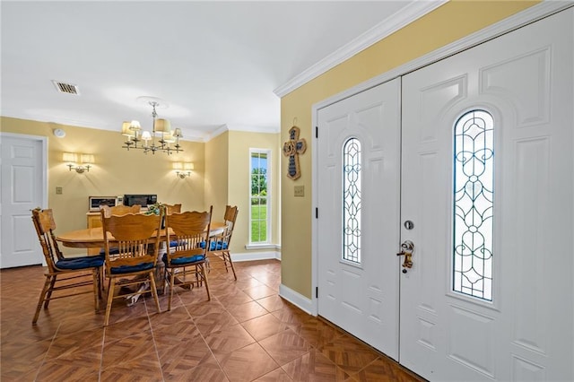 entryway with ornamental molding, visible vents, a notable chandelier, and baseboards