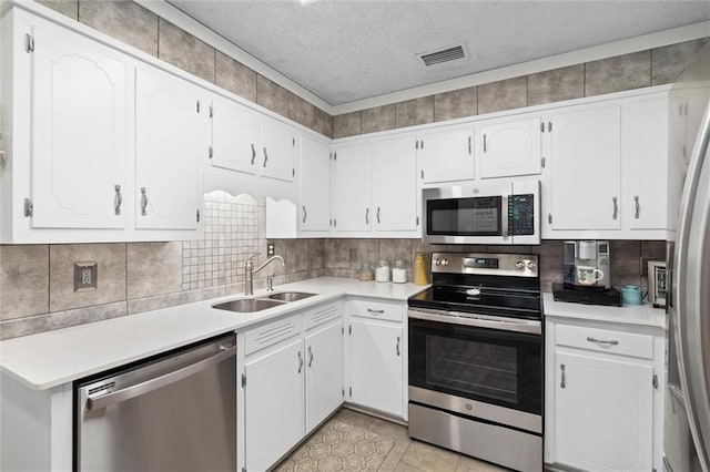 5719 Laurel Dr, Satsuma, AL 36572 - kitchen with stainless steel appliances, a sink, white cabinetry, a textured ceiling, and light countertops