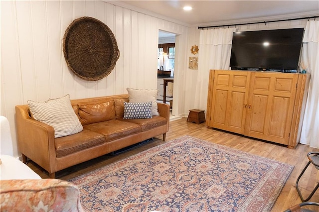 living room featuring crown molding and light wood-type flooring