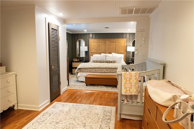 bedroom with hardwood / wood-style floors and ornamental molding