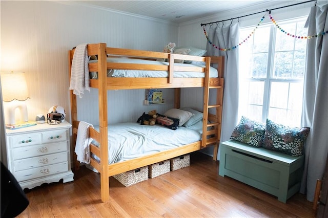 bedroom with hardwood / wood-style floors and ornamental molding