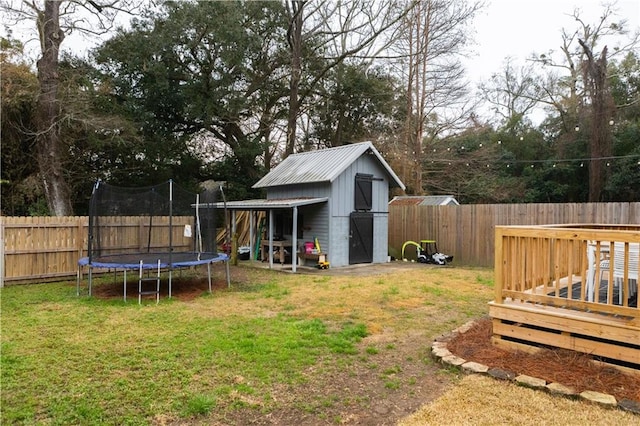 view of yard with a deck, a trampoline, and a shed