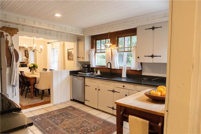 kitchen featuring stainless steel dishwasher, a chandelier, sink, and white cabinets