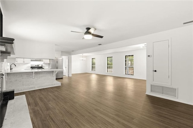 unfurnished living room featuring ceiling fan and dark hardwood / wood-style flooring