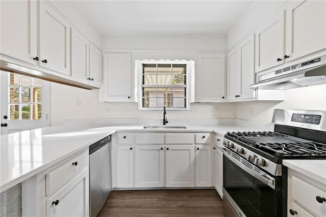 kitchen featuring white cabinets, stainless steel appliances, kitchen peninsula, dark wood-type flooring, and sink