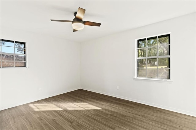 spare room featuring ceiling fan, dark hardwood / wood-style flooring, and plenty of natural light