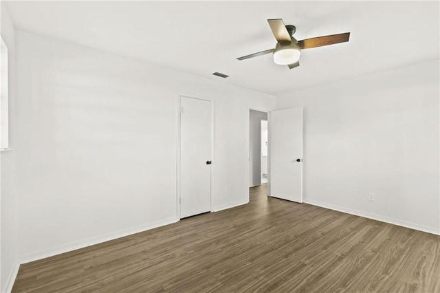 unfurnished room with ceiling fan and dark hardwood / wood-style floors