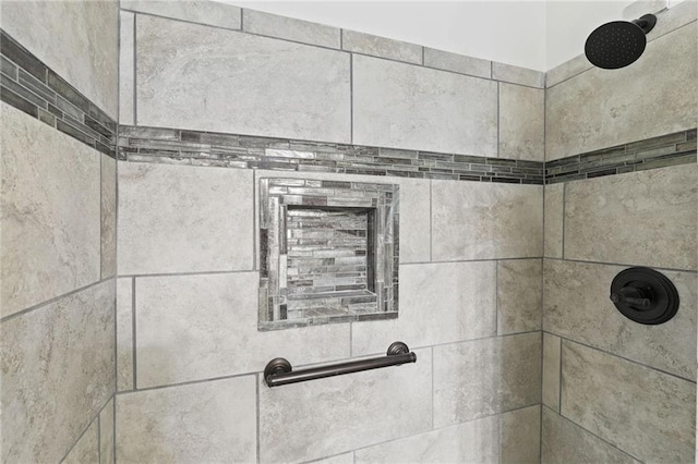 interior details featuring tiled shower