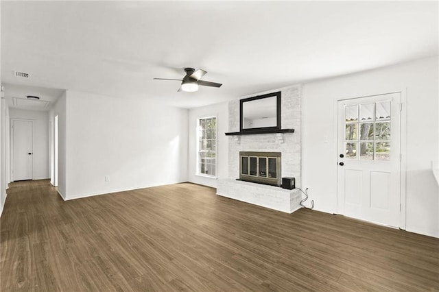 unfurnished living room with ceiling fan, a brick fireplace, and dark hardwood / wood-style floors