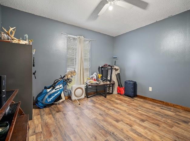 miscellaneous room with hardwood / wood-style flooring, ceiling fan, and a textured ceiling