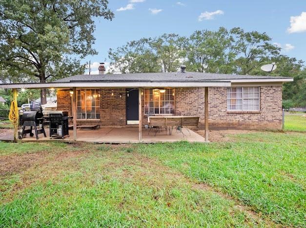 back of house featuring a patio and a lawn