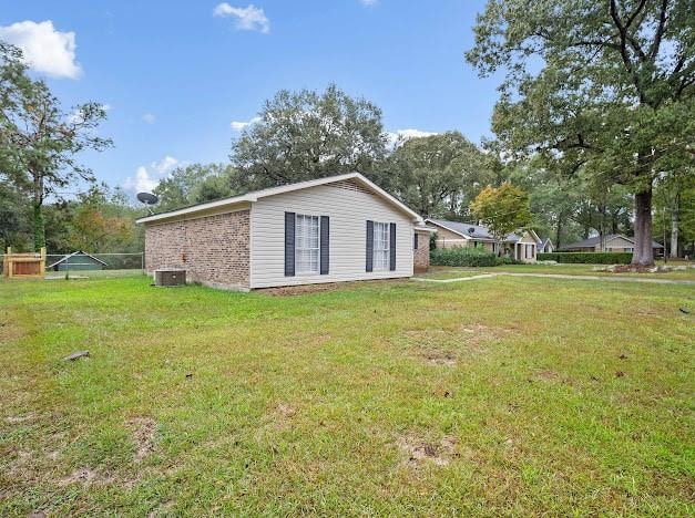 view of property exterior featuring cooling unit and a lawn