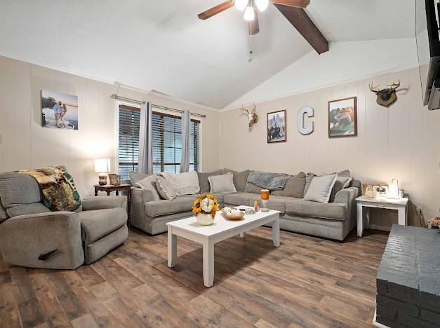 living room featuring ceiling fan, vaulted ceiling with beams, and dark hardwood / wood-style floors