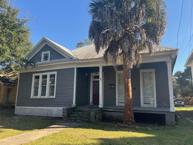 view of front of house featuring covered porch and a front yard