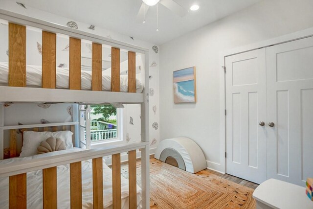 laundry room with wood-type flooring and stacked washing maching and dryer