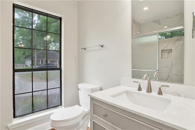 full bathroom featuring toilet, vanity, and a marble finish shower