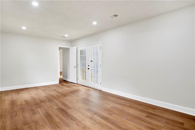 spare room with recessed lighting, french doors, baseboards, and light wood finished floors