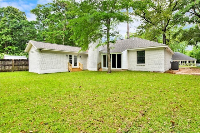 rear view of property with entry steps, brick siding, central air condition unit, french doors, and a shingled roof