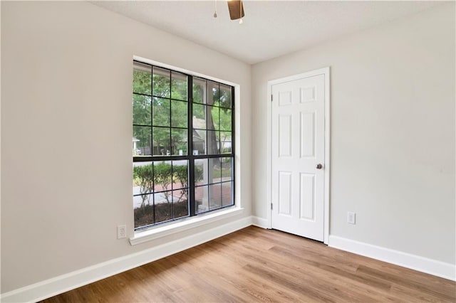 unfurnished room with baseboards, wood finished floors, and ceiling fan