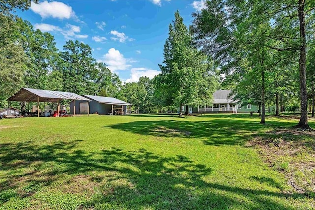 8255A Dixon Rd, Bay Minette, AL 36507 - view of green lawn featuring a detached carport, a pole building, and view of scattered trees