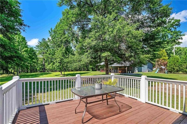 8255A Dixon Rd, Bay Minette, AL 36507 - deck with a lawn, an outdoor structure, a playground, and view of scattered trees